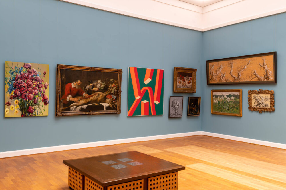 Eine blaue Wand mit Werken aus der Sammlung der Landesgalerie und von Glenn Brown.