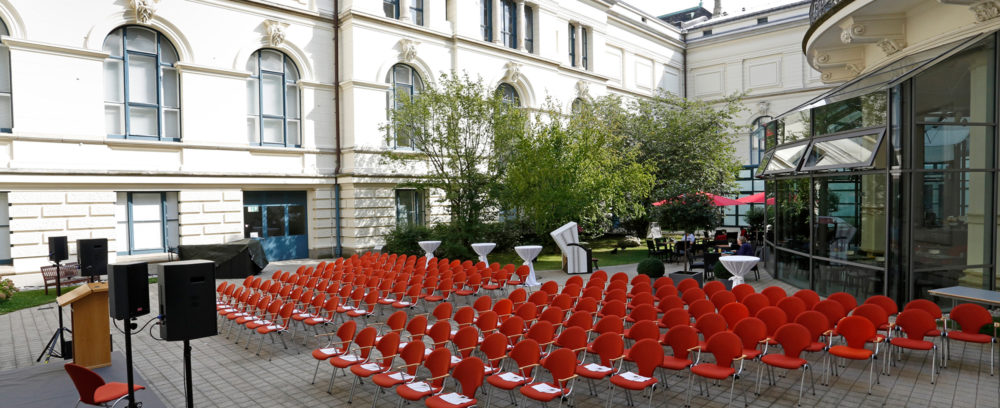 Der Innenhof des Landesmuseums bei Sonnenschein mit Bestuhlung und aufgebauter Bühne.